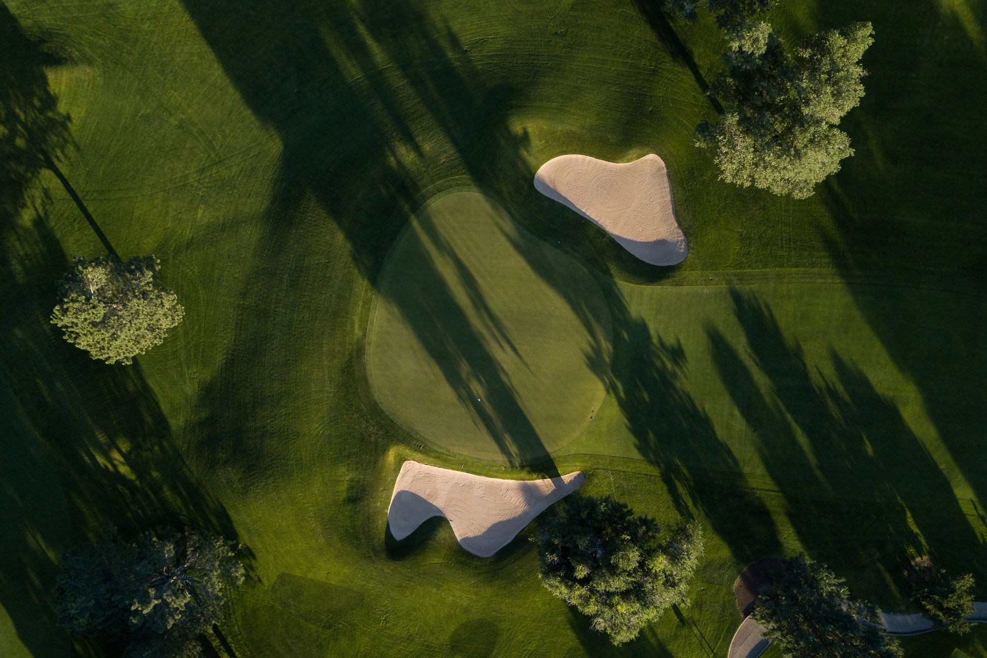 Overhead view of a golf green that is flanked on both sides by bunkers.