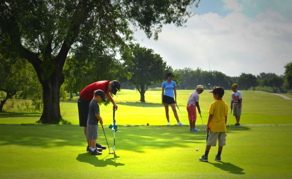 Golf instructor with students on golf course hole