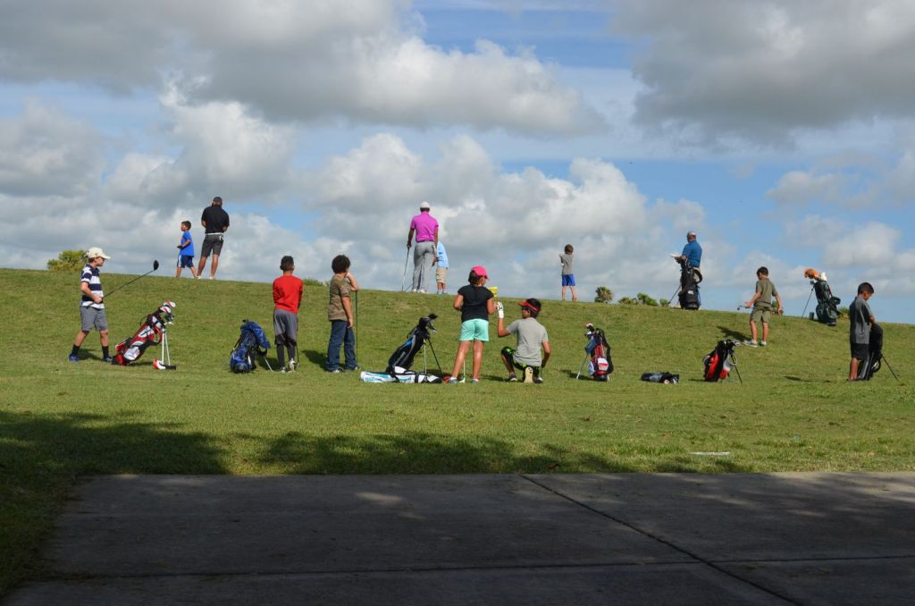 Golf course with young golfers and instructors